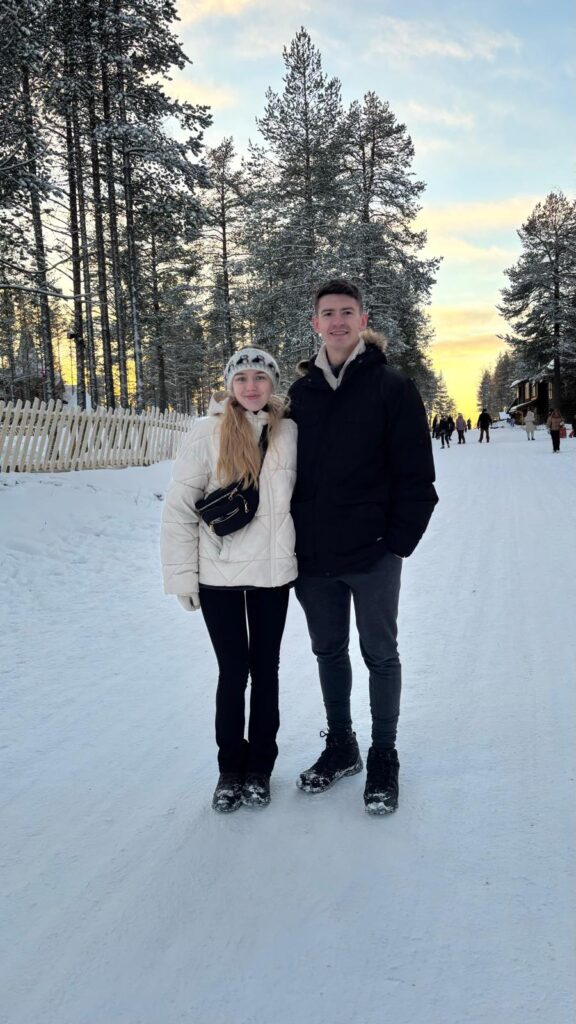 Charlotte and Josh standing amongst the snow in Santa Claus Village
